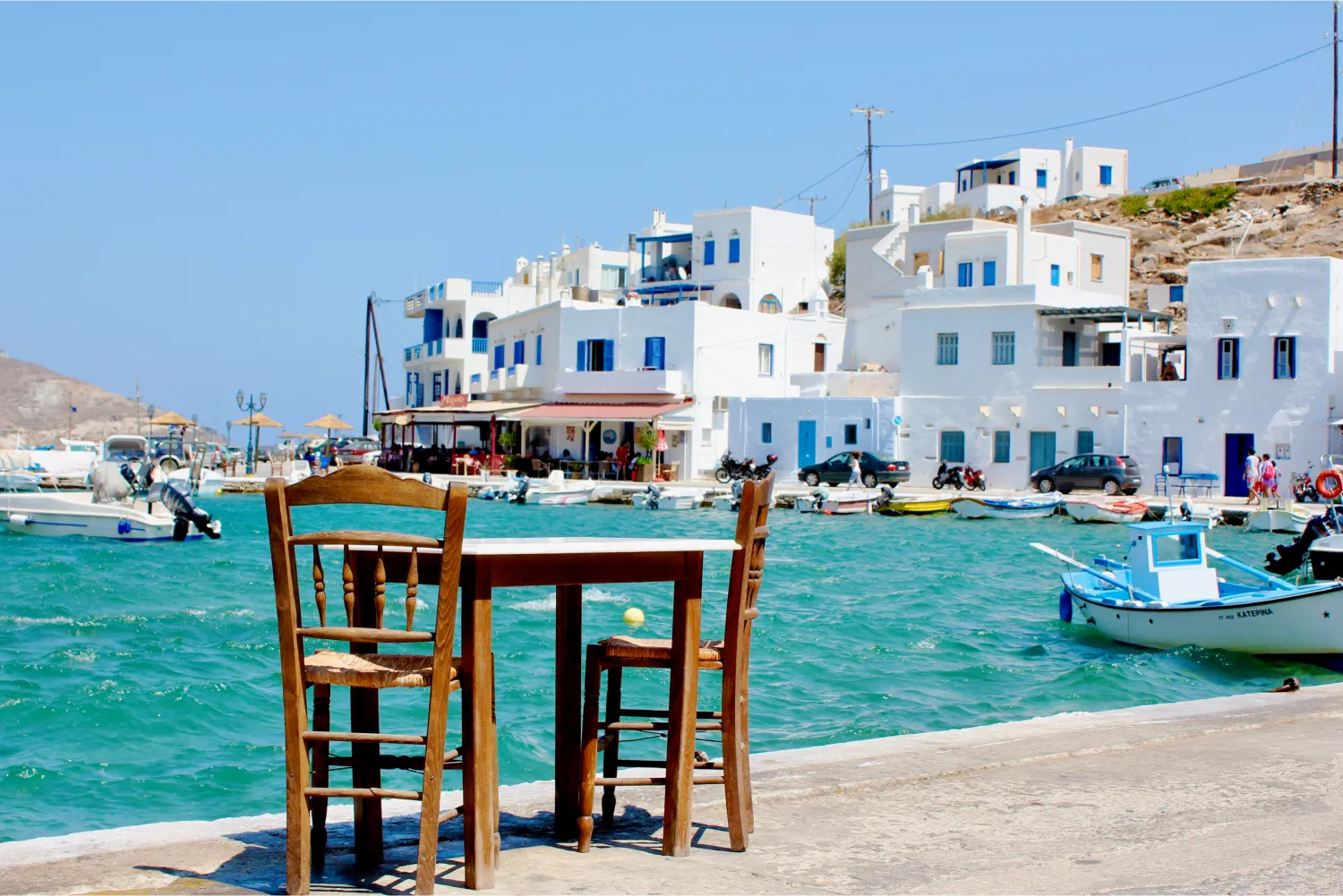 Ένα τραπέζι για δύο περιμένει τους επισκέπτες δίπλα σε ένα γραφικό λιμάνι στην Τήνο