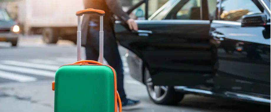 Πράσινη βαλίτσα που περιμένει να φορτωθεί σε ταξί
