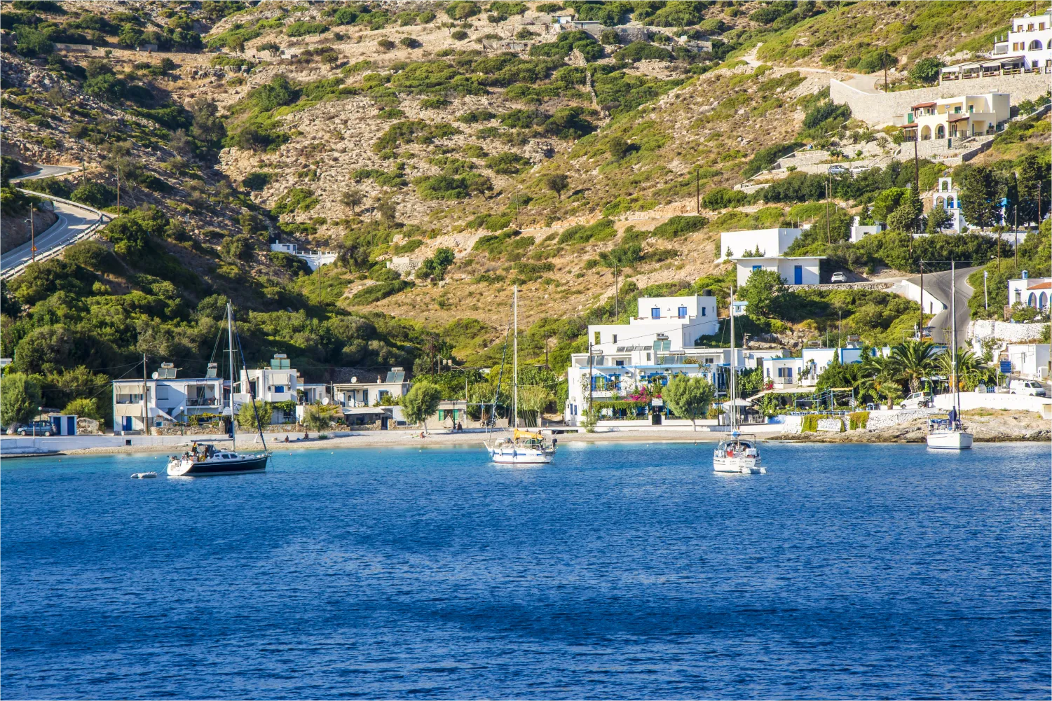 'Eνας μικρός κόλπος με βάρκες, με φόντο το βουνό στο Αγαθονήσι